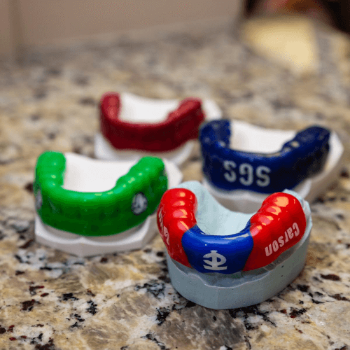 Four impression guards on teeth molds.