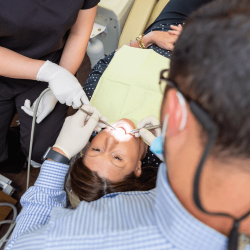 Overhead view of a dentist cleaning a patients teeth.