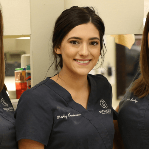 Smiling dental team member wearing scrubs at a family dentistry office.