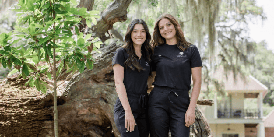 Two Breaux Bridge Family Dentistry employees in their scrubs outside.