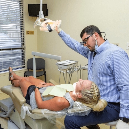 dentist pointing exam light a patient in chair