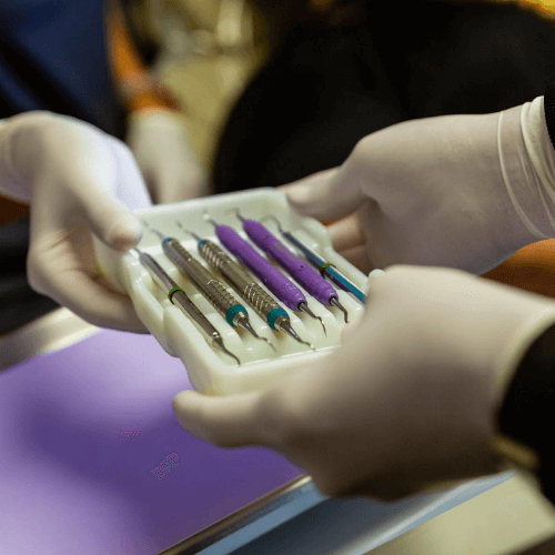 dental tools in a mold being handed to another dentist